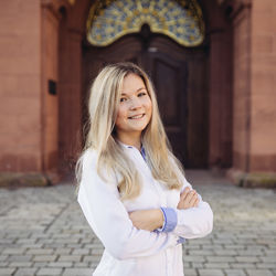 Nadine Wendrowski in weißer Bluse vor dem Schloss