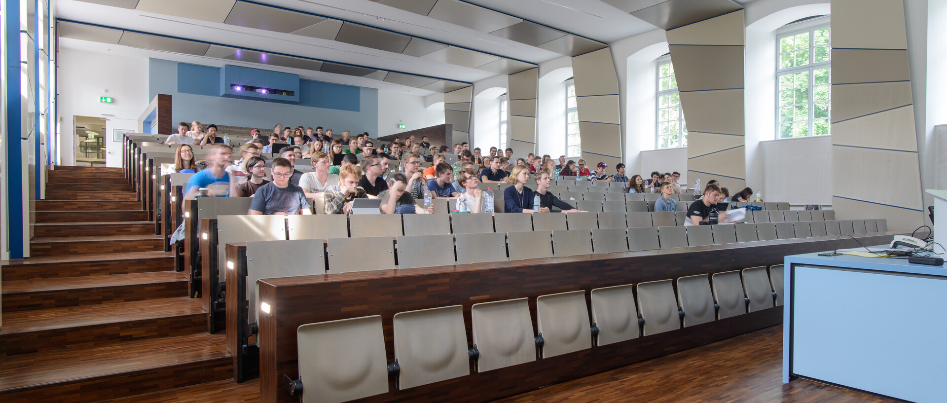 Dekoratives Bild, auf welchem Studierende in einem Hörsaal einer Vorlesung folgen.