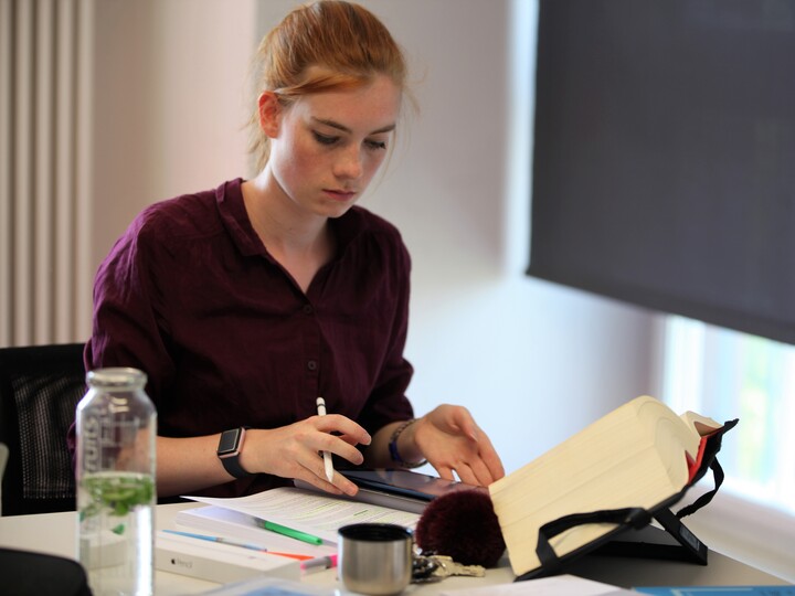 Studentin, die etwas liest.