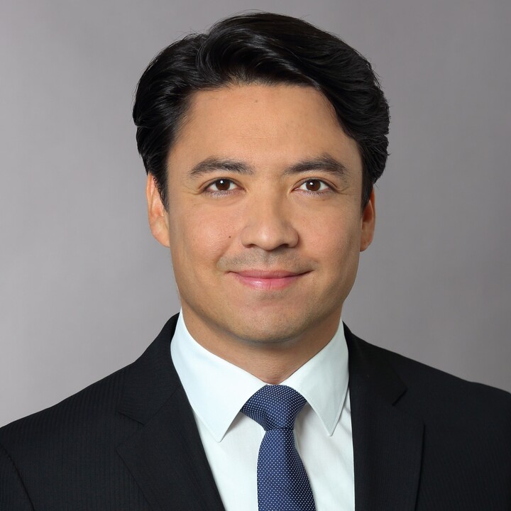 Bajar Scharaw in black suit and tie smiling into camera