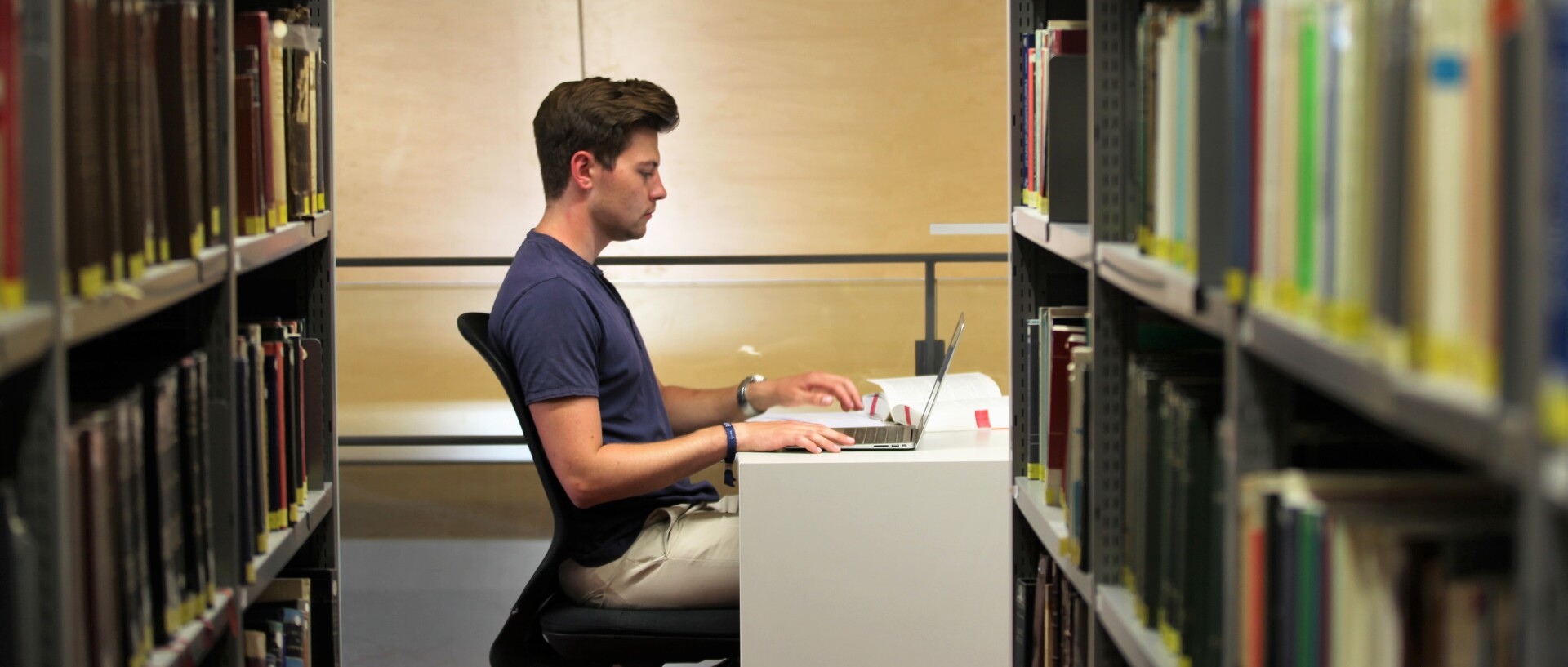 Student sitzt in Bibliothek und liest