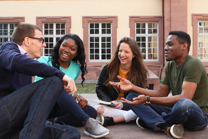 Eine Gruppe Studierender sitzt im Kreis und unterhält sich