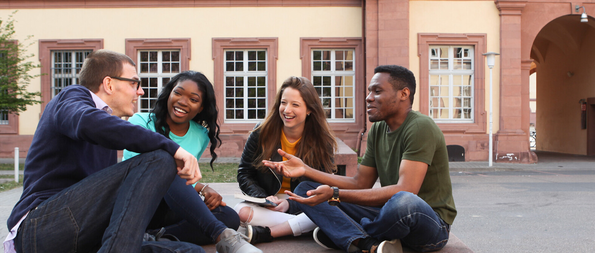 Group of students sitting on courtyard outside the palace