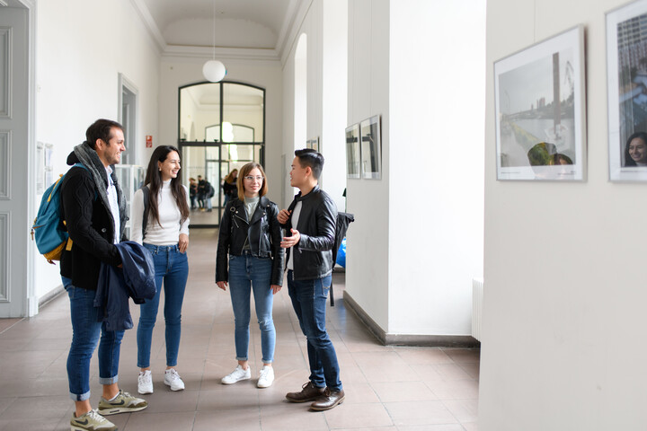 Vier Studierende unterhalten sich in einem Flur der Universität