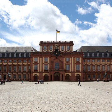 Barockschloss mit Ehrenhof an einem leicht bewölkten Tag.