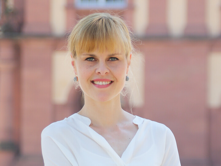 Lea Tochtermann in weißer Bluse vor dem Schloss