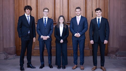 Gruppe von Studierender in formeller Kleidung vor dem Schloss