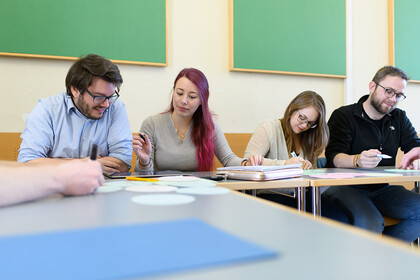 Studierende müssen Stichpunkte mit Filzstiften auf kleine Zettel schreiben.