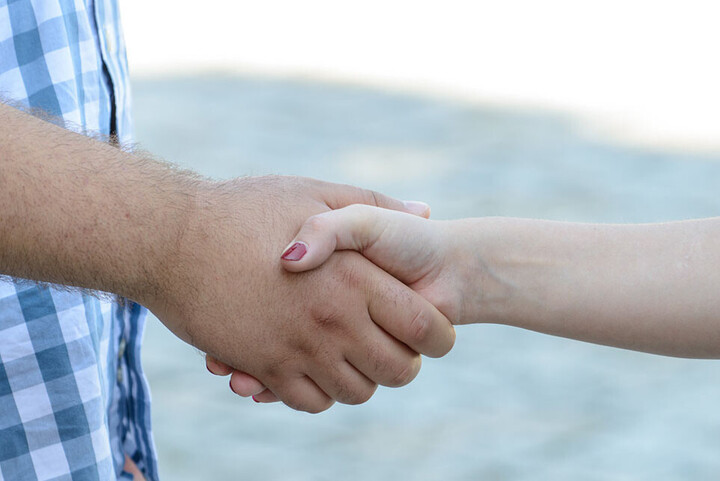 Zwei Hände geben sich einen Handschlag