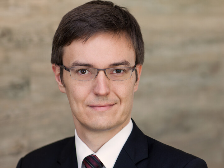 Erik Röder in black suit smiling into camera