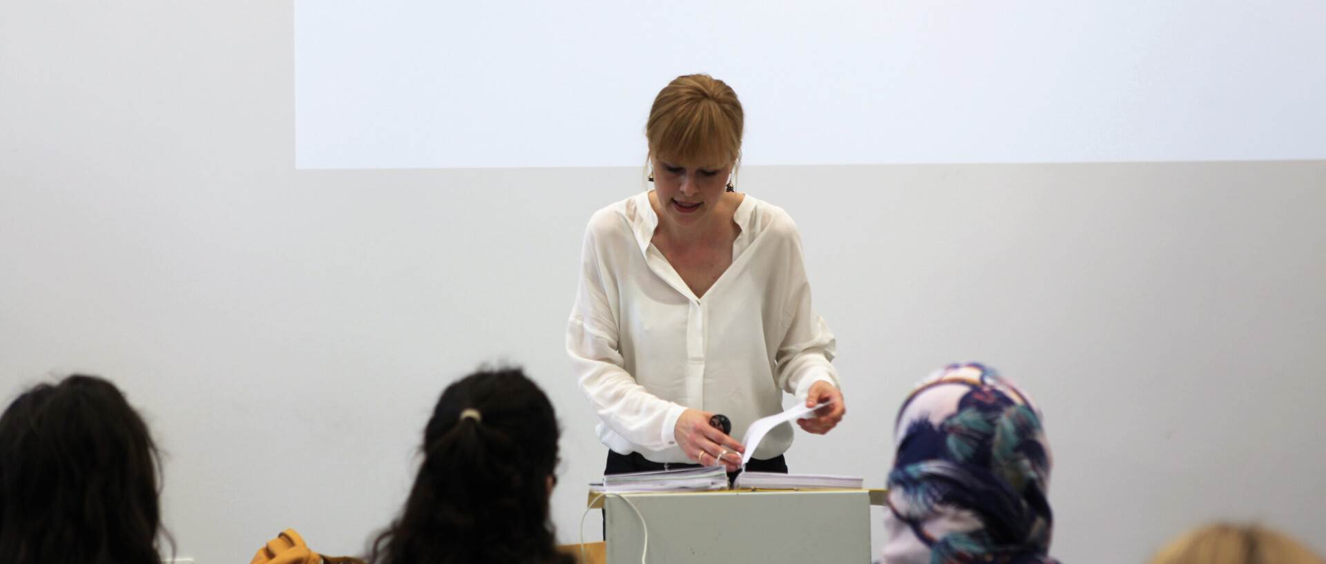 Lecturer with two students in front row, listening