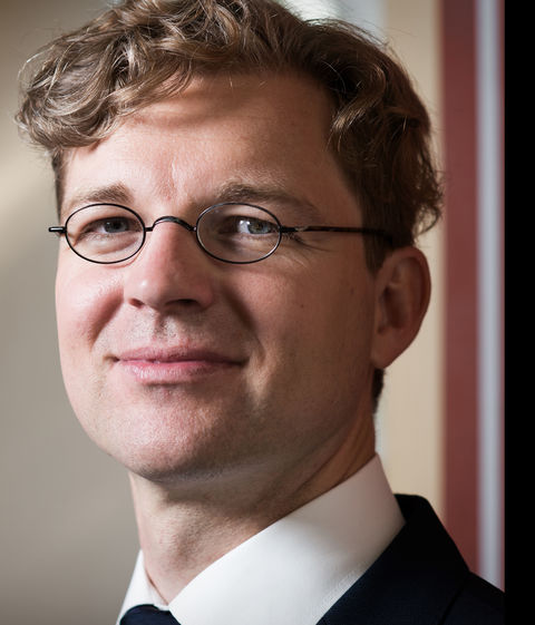 Jens-Uwe Franck in black suit smiling into camera