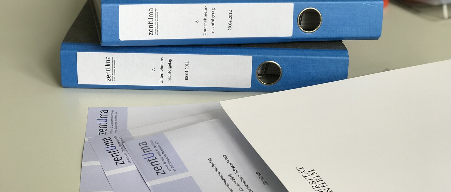 Zu sehen sind Ordner und Briefpapier von zentUma sowie eine Tagungsmappe der Universität Mannheim