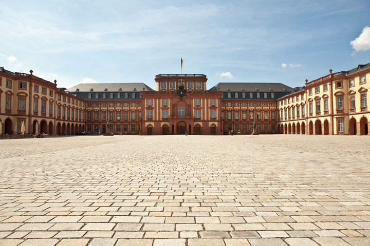 Das Mannheimer Barockschloss und der Ehrenhof unter blauem Himmel.