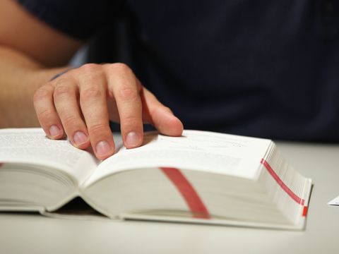 Buch mit Markierungen und einer Hand, die auf etwas zeigt