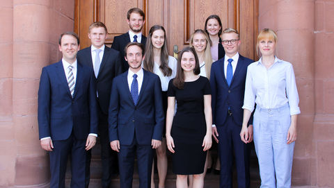 Gruppe von Studierender in formeller Kleidung vor dem Schloss