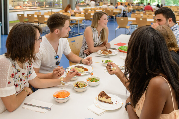 Students sitting at a table together eating