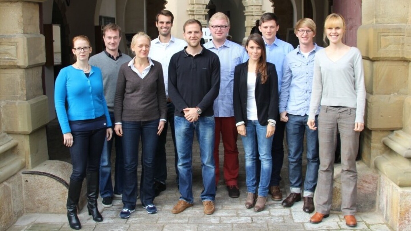 Gruppe von Studierender in formeller Kleidung vor dem Schloss