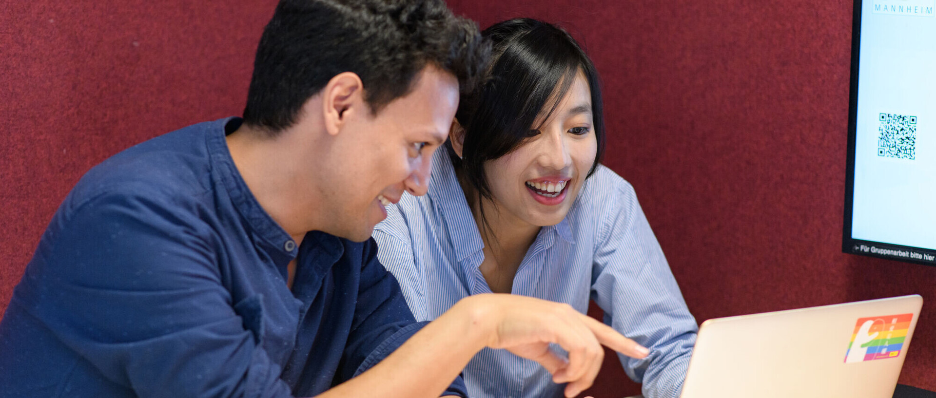 Eine Studentin und ein Student lernen gemeinsam an einem Laptop.