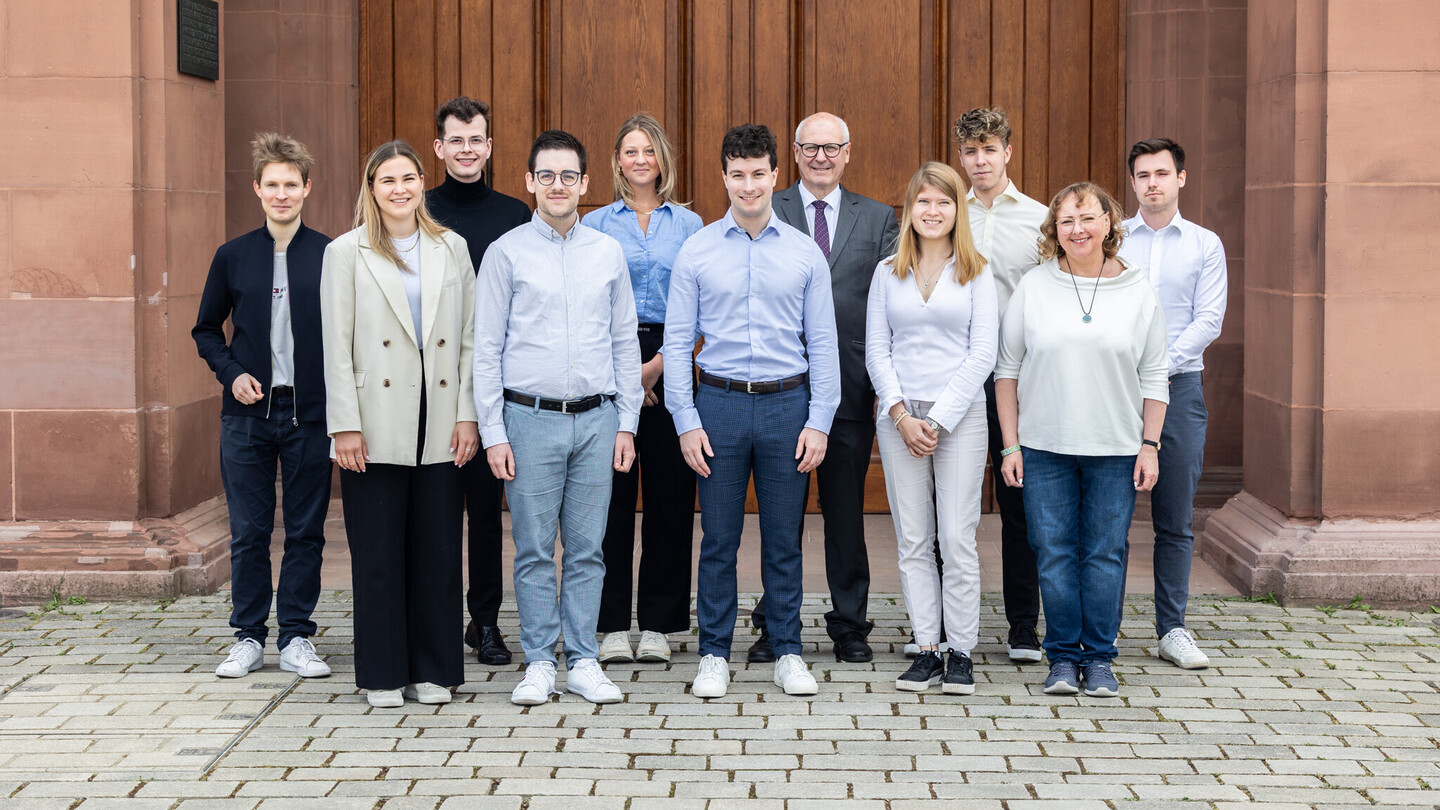 Die Mitarbeiter von Dr. Wirth stehen mit ihm vor dem Schloss