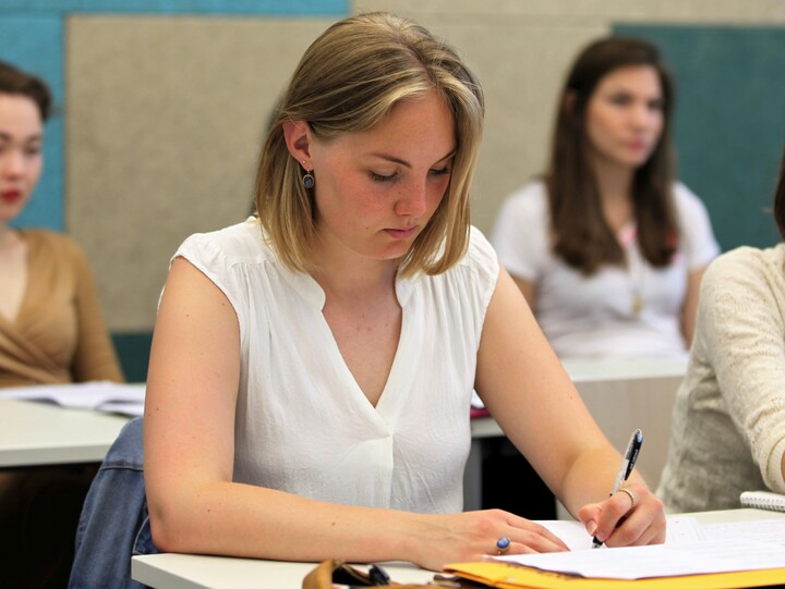 Studentin schreibt in ein Notizbuch