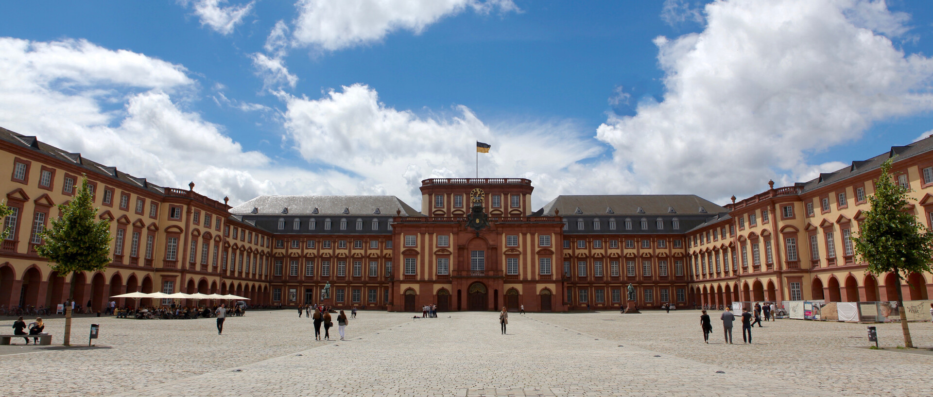 Ehrenhof und Schloss im Sonnenschein, blauer Himmel mit weißen Wolken