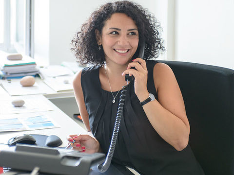 Frau mit schwarzem Kleid telefoniert