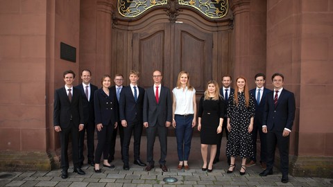 Gruppe von Studierender in formeller Kleidung vor dem Schloss