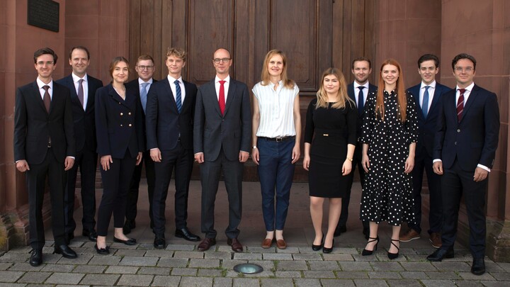 Gruppe von Studierender in formeller Kleidung vor dem Schloss